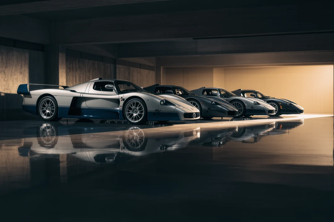 A vintage gold supercar is parked inside an empty, industrial-style garage with concrete floors and white brick walls.