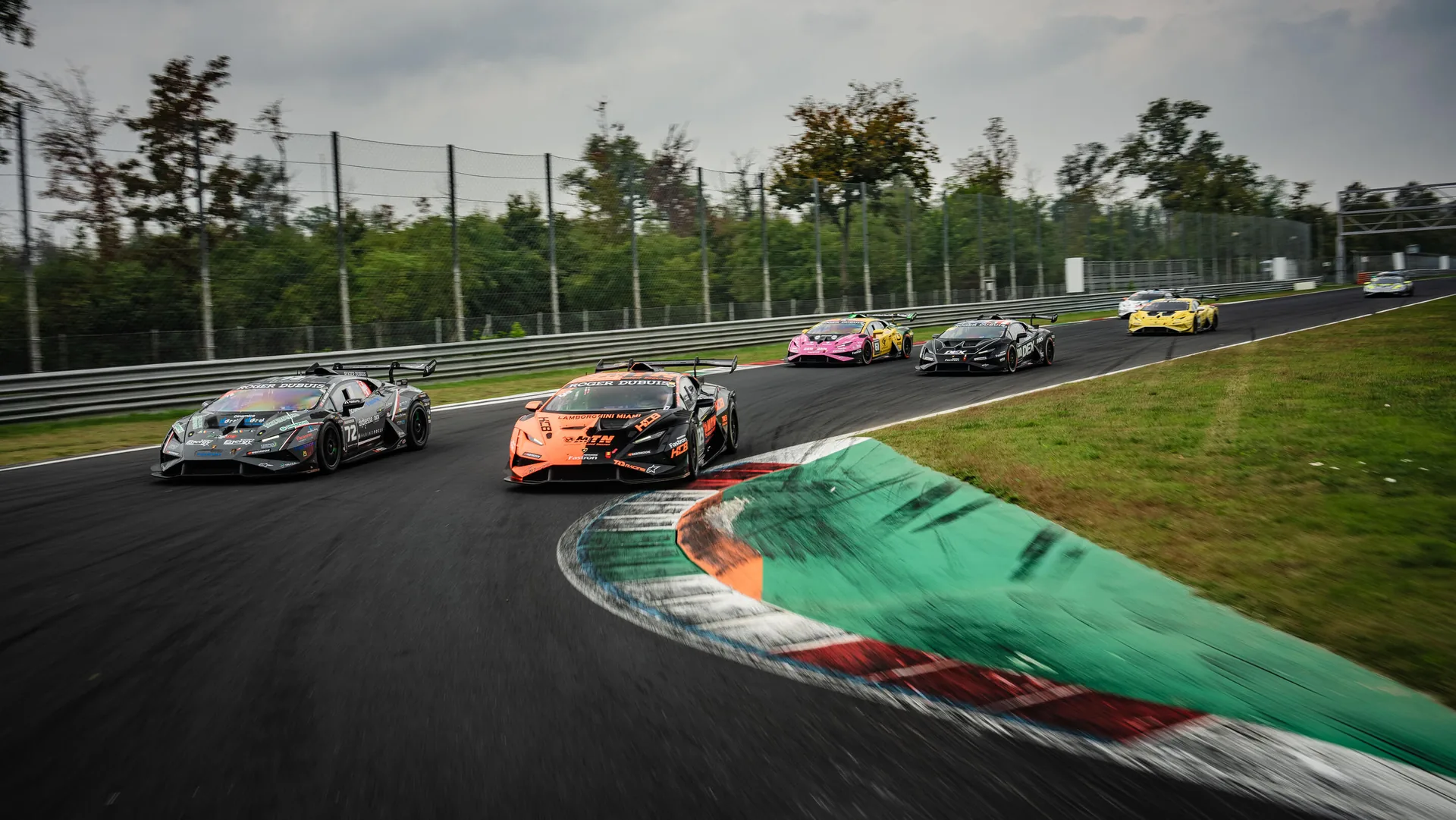 Lamborghini Huracán Super Trofeo race cars taking a corner over the kerb