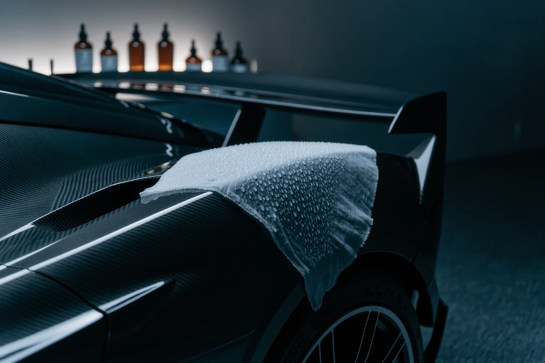 A red cloth partially covers the front of a car, revealing the iconic Ferrari logo on a visible section of the hood—a striking glimpse into the world of supercars.